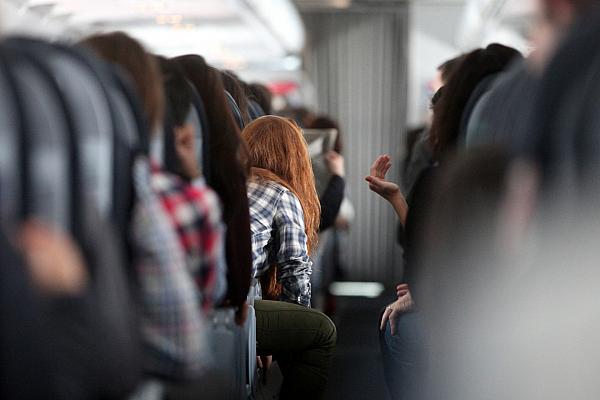 Rothaarige Frau in einem Flugzeug, über dts Nachrichtenagentur